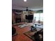 Cozy living room featuring a stone fireplace, wood floors, ceiling fan, and ample natural light from large windows at 4746 Cr 300, Lake Panasoffkee, FL 33538