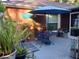 Outdoor patio area with a blue table and chairs, accented by plants and an umbrella, ideal for relaxing outside at 4746 Cr 300, Lake Panasoffkee, FL 33538