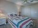 Bright bedroom featuring a ceiling fan, neutral walls, and a bed with a decorative white headboard and quilt at 507 Torres Pl, The Villages, FL 32159