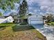Charming single-story home featuring a white exterior, attached garage, and well-maintained front yard landscaping at 507 Torres Pl, The Villages, FL 32159