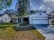 Charming home boasts a well-manicured lawn, mature landscaping, and an attached two-car garage at 507 Torres Pl, The Villages, FL 32159