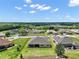 Aerial view of neighborhood with manicured lawns, mature trees, and a beautiful lake at 5195 Greens Dr, Lady Lake, FL 32159