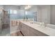 Bright bathroom featuring double sinks, a large mirror, and a walk-in shower at 5195 Greens Dr, Lady Lake, FL 32159