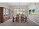 Bright dining room with wood floors, a modern chandelier, and a large window overlooking the green yard at 5195 Greens Dr, Lady Lake, FL 32159