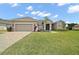 Charming single Gathering home featuring a well-manicured lawn, paver driveway, and two-car garage at 5195 Greens Dr, Lady Lake, FL 32159