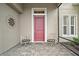 Inviting front porch with seating area showcasing a decorative metal art piece and striking red front door at 5195 Greens Dr, Lady Lake, FL 32159