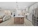 Open kitchen with a large island featuring seating, stainless steel appliances, and seamless connection to the living area at 5195 Greens Dr, Lady Lake, FL 32159