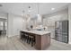 Modern kitchen featuring a large center island with seating, stainless steel appliances, and stylish pendant lighting at 5195 Greens Dr, Lady Lake, FL 32159