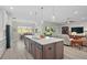 Open-concept kitchen with island seating, stainless steel appliances, and a seamless transition to the dining and living areas at 5195 Greens Dr, Lady Lake, FL 32159