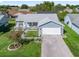 Aerial view of a well-kept single-story home featuring a manicured lawn and brick driveway at 530 Valencia Pl, The Villages, FL 32159