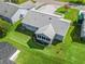 Aerial view of the home showcasing the backyard, sunroom, and surrounding greenery at 530 Valencia Pl, The Villages, FL 32159