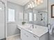 Bright bathroom featuring white cabinets, marble countertops, a framed mirror, and a glass-enclosed shower at 530 Valencia Pl, The Villages, FL 32159
