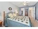 Cozy bedroom with a quilt-covered bed, decorative wreath, and an en-suite bathroom entrance at 530 Valencia Pl, The Villages, FL 32159