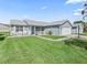Well-maintained single-story home with a brick driveway, manicured lawn, and charming front porch at 530 Valencia Pl, The Villages, FL 32159