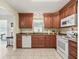 Traditional kitchen featuring cherry cabinets, granite counters and white appliances at 530 Valencia Pl, The Villages, FL 32159