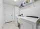 Clean laundry room with washer, dryer, utility sink, shelving, and storage at 530 Valencia Pl, The Villages, FL 32159
