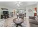 Inviting living room featuring wood floors, a ceiling fan, and views into the kitchen at 530 Valencia Pl, The Villages, FL 32159