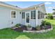 Enclosed sunroom addition with multiple windows, outdoor access, and decorative landscaping at 530 Valencia Pl, The Villages, FL 32159