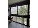 Balcony featuring lush trees and partial water view, complete with hammock seat at 601 N Mcdonald St # 408, Mount Dora, FL 32757