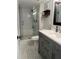 Updated bathroom with modern gray vanity and glass-enclosed shower at 601 N Mcdonald St # 408, Mount Dora, FL 32757