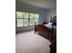 Comfortable bedroom with neutral carpeting and a traditional wooden bed frame at 601 N Mcdonald St # 408, Mount Dora, FL 32757