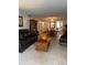 Inviting living room featuring a leather sofa, a wooden bookcase, and neutral carpeting at 601 N Mcdonald St # 408, Mount Dora, FL 32757