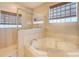 Bright bathroom featuring a soaking tub, glass-enclosed shower, and tiled walls at 605 Westview Dr, Minneola, FL 34715