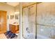 Bright bathroom with a gold-framed shower, vanity with wood cabinets, and a blue rug at 605 Westview Dr, Minneola, FL 34715
