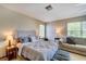 Bedroom featuring plush bed with side tables and lamps, and a sofa sitting area at 605 Westview Dr, Minneola, FL 34715