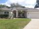 Beautiful single-story home with a well-manicured lawn, arched entryway, and a two-car garage at 605 Westview Dr, Minneola, FL 34715