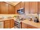 Modern kitchen featuring granite countertops, stainless steel appliances, and updated wooden cabinets at 605 Westview Dr, Minneola, FL 34715