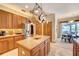 Bright kitchen with a center island, wooden cabinets, stainless steel refrigerator, and open dining area at 605 Westview Dr, Minneola, FL 34715