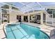 Screened-in pool and hot tub area with covered patio, seating, and outdoor kitchen at 605 Westview Dr, Minneola, FL 34715