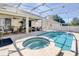 Screened-in pool and hot tub with covered patio, seating, and an outdoor kitchen at 605 Westview Dr, Minneola, FL 34715