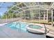 This screened in pool features a large swimming pool with a jacuzzi, great for beating the summer heat at 605 Westview Dr, Minneola, FL 34715
