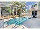 Screened-in pool and hot tub are surrounded by a concrete deck and lush landscaping at 605 Westview Dr, Minneola, FL 34715