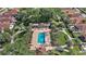 Aerial view of the community pool surrounded by lush greenery and seating and well-maintained landscaping at 623 Delgado Ave, The Villages, FL 32159