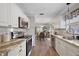 Beautiful kitchen with stainless appliances, white cabinets, granite counters, and wood floors that flow into dining and living spaces at 623 Delgado Ave, The Villages, FL 32159