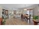 Open-concept living and dining area featuring wood flooring, contemporary furnishings, and sliding glass doors to the outside at 623 Delgado Ave, The Villages, FL 32159