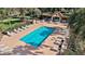 A relaxing outdoor community pool surrounded by lounge chairs and palm trees, offering a perfect spot for recreation at 623 Delgado Ave, The Villages, FL 32159