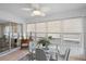 Sunroom featuring tile floors, multiple windows with blinds, and a glass table with seating at 623 Delgado Ave, The Villages, FL 32159