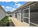 Covered patio and backyard with a sliding glass door that leads to the interior at 6248 Siverson Ter, The Villages, FL 32163