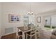 Bright dining room featuring a wood table with white chairs, chandelier, and access to the backyard at 6248 Siverson Ter, The Villages, FL 32163