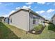 The back of a home featuring vinyl siding, green grass and a garden area at 6248 Siverson Ter, The Villages, FL 32163