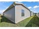 Side view of a single-story home featuring vinyl siding, green grass, and a blue sky at 6248 Siverson Ter, The Villages, FL 32163