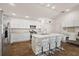 Bright kitchen featuring a large island, white cabinets, stainless appliances, and hardwood floors at 6248 Siverson Ter, The Villages, FL 32163