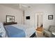 Comfortable bedroom features a large bed, dresser with mirror, chair, and access to an ensuite bathroom at 6248 Siverson Ter, The Villages, FL 32163