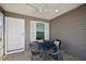 Cozy covered patio features neutral siding, an outdoor ceiling fan, and a charming four-seat dining set at 6248 Siverson Ter, The Villages, FL 32163