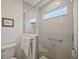 Modern bathroom shower featuring white subway tile, grab bar, shower niche, and glass door at 6248 Siverson Ter, The Villages, FL 32163