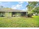 View of the home's backyard featuring a screened-in patio and outdoor seating area at 638 Mount Homer Rd # 3-C, Eustis, FL 32726